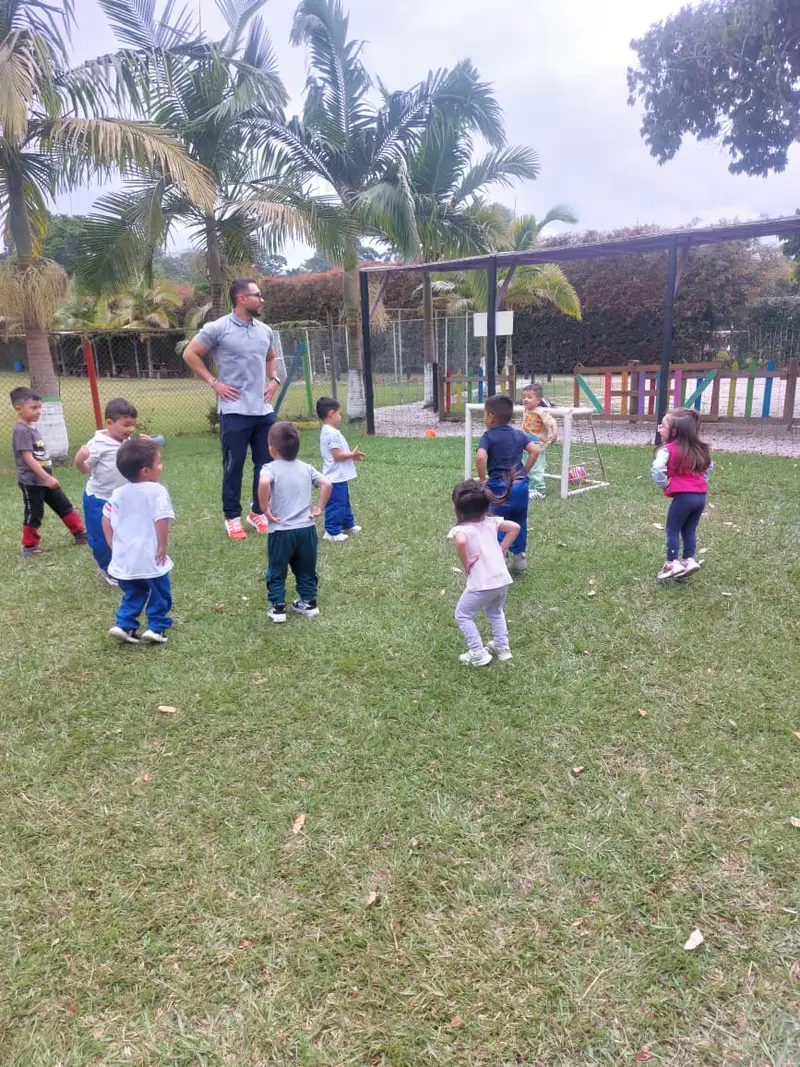 Niños de prejardín y jardín jugando al aire libre en la manga del colegio